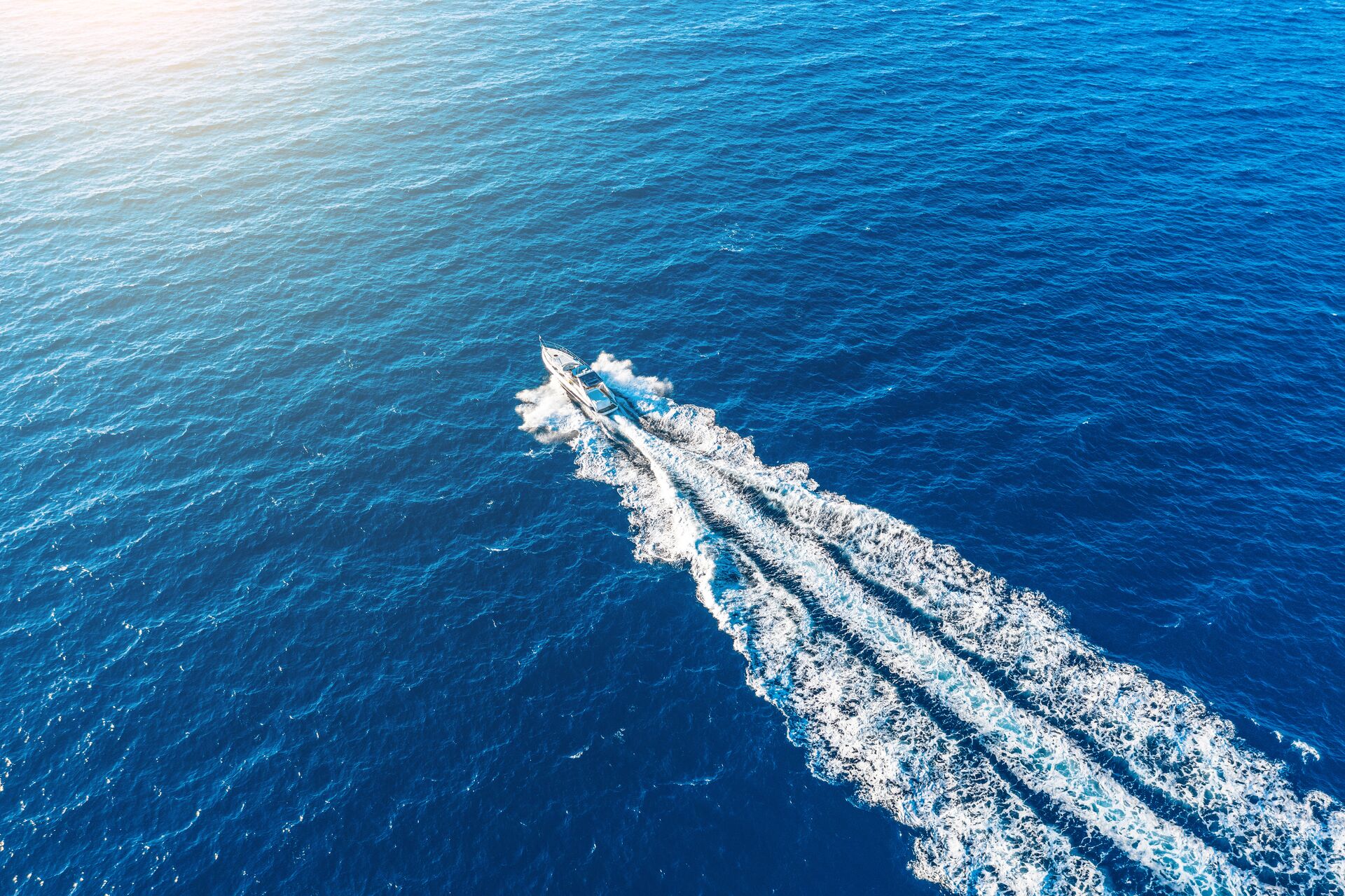 Aerial view of a boat moving quickly on open waters. 