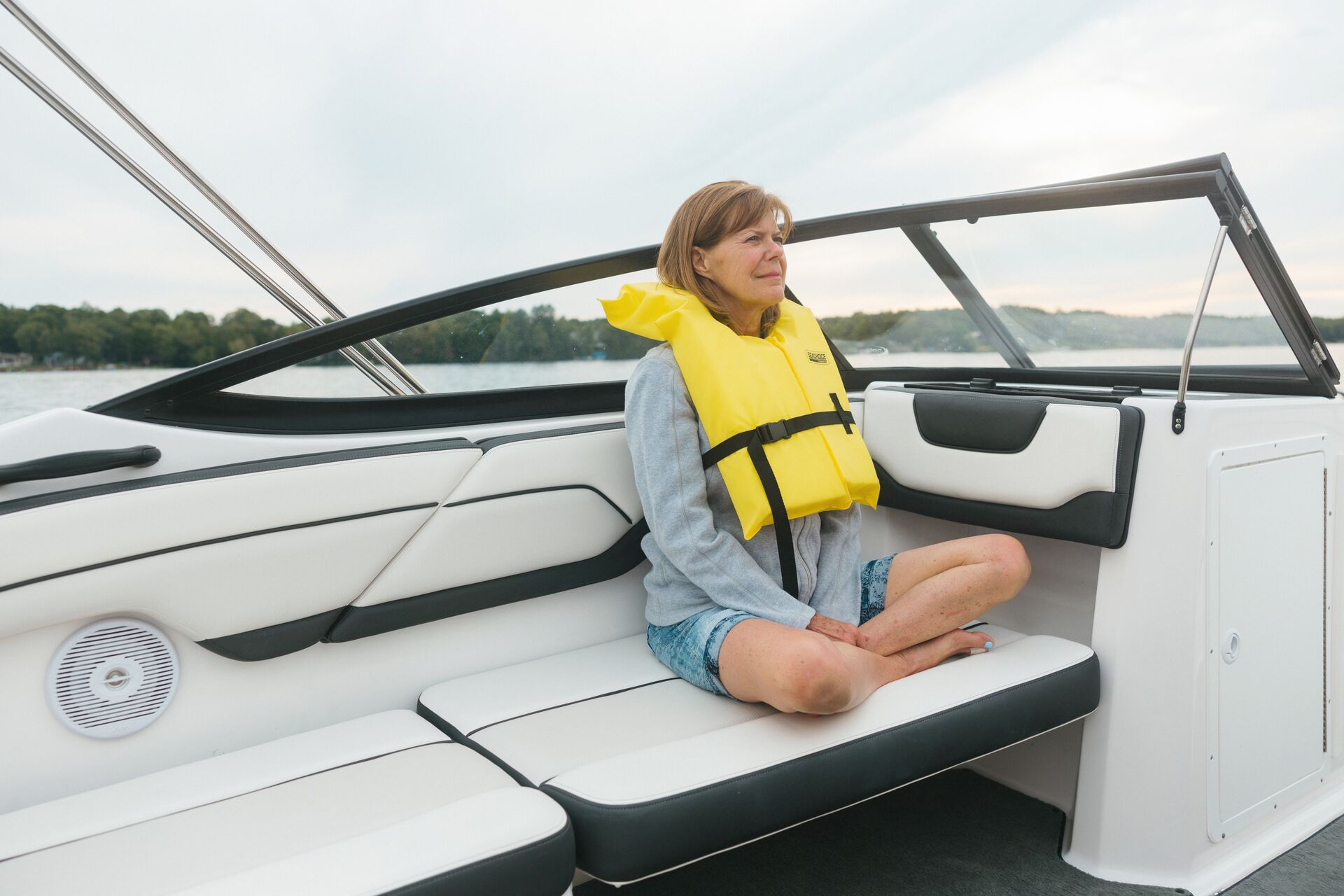 Woman in yellow life vest on boat, how to stop seasickness concept.