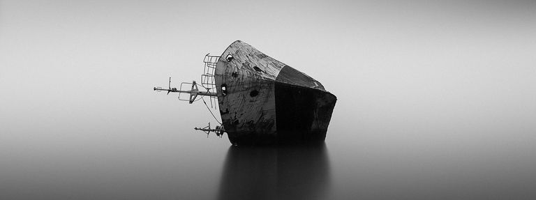 A ship laying on its side in the water, how to survive a sinking ship concept. 