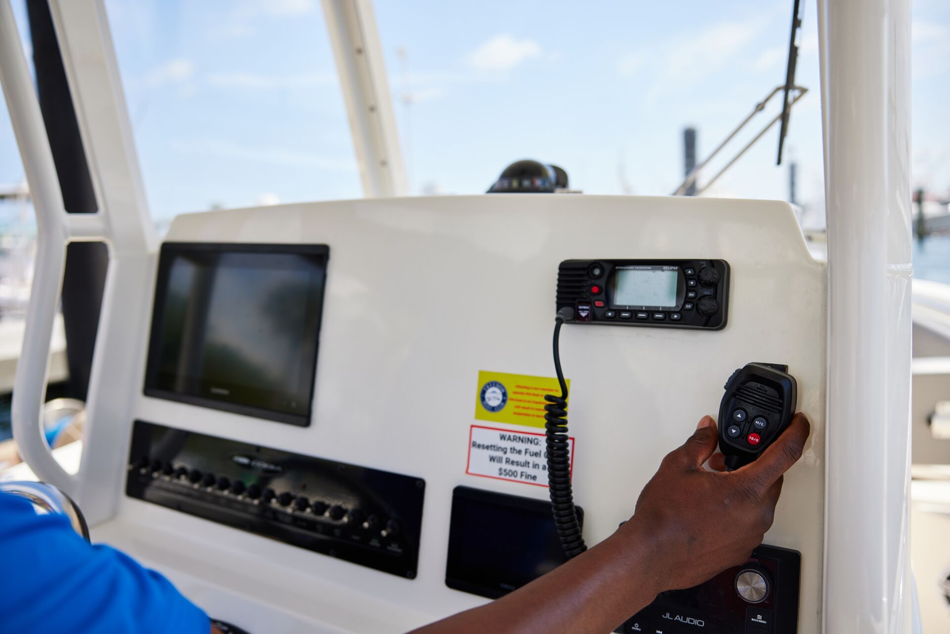 Close-up of a hand on a marine radio, what is a mayday call concept.