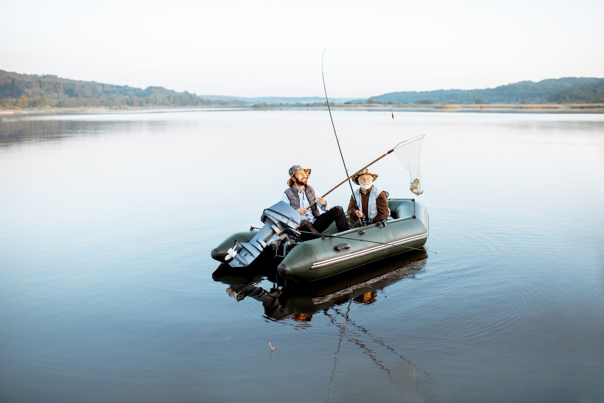 Two men fishing on the water, using inflatable fishing boat Canada concept.