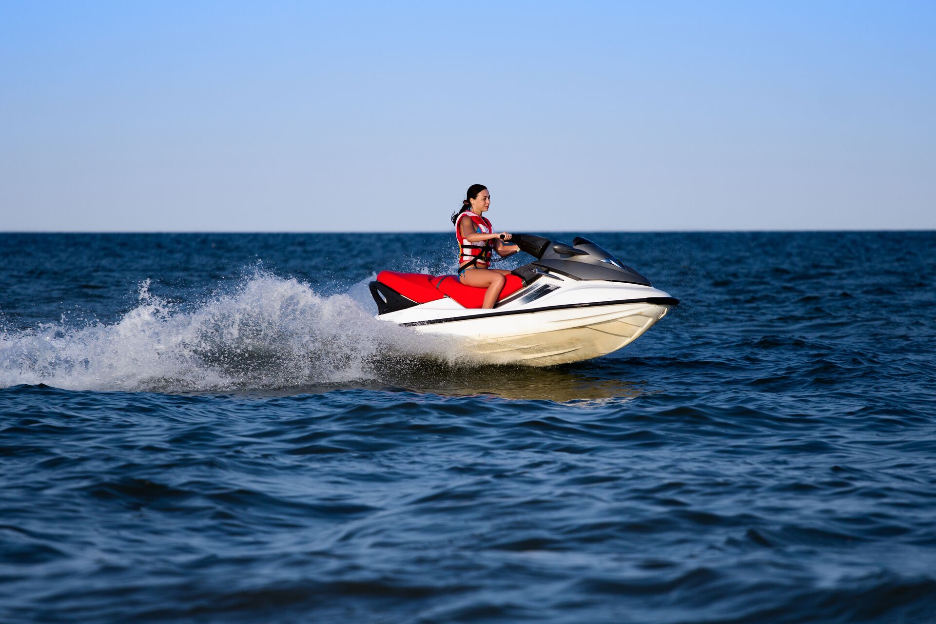 Side view of girl riding PWC, jet ski launching concept. 