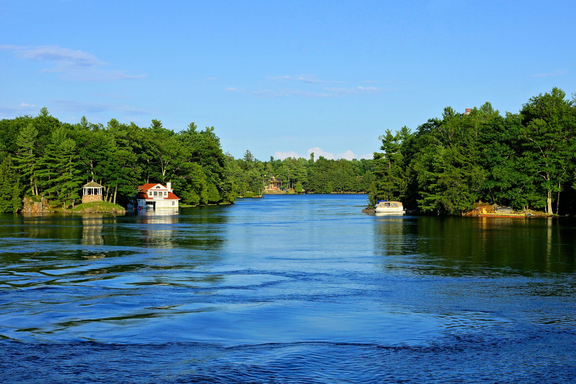 Cottages on land lining a waterway.