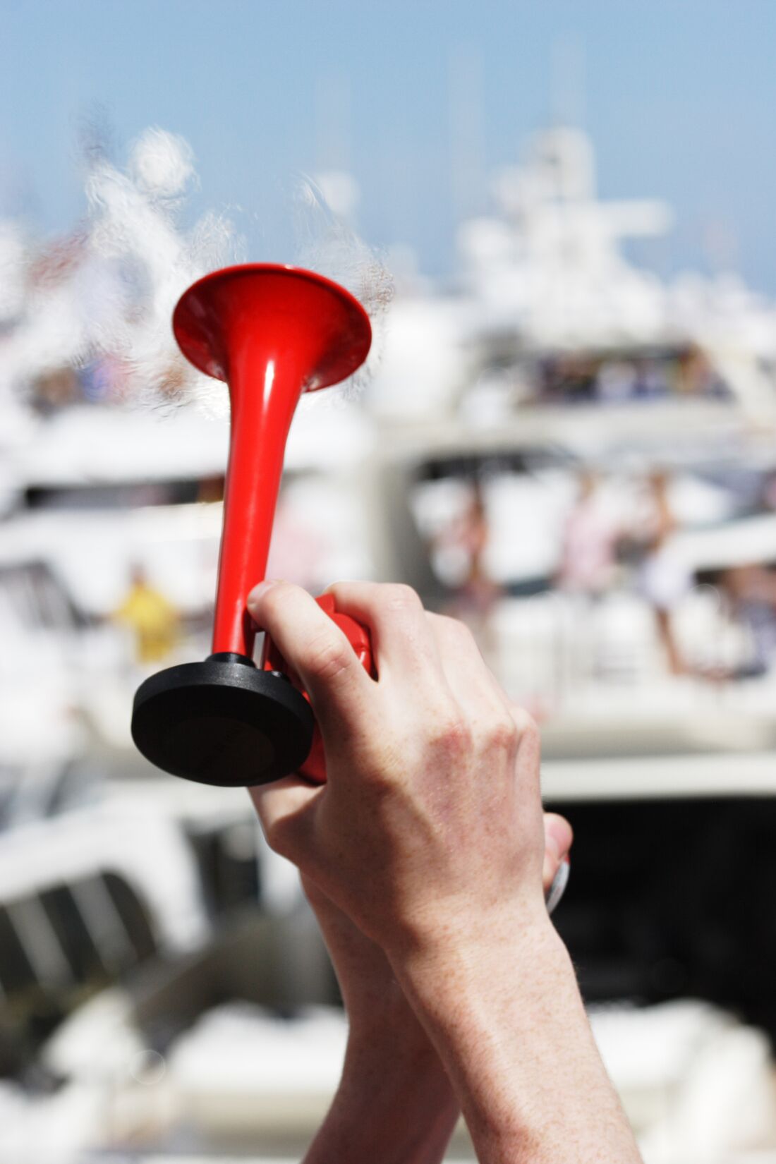 Hand holds horn for boat sound signaling.