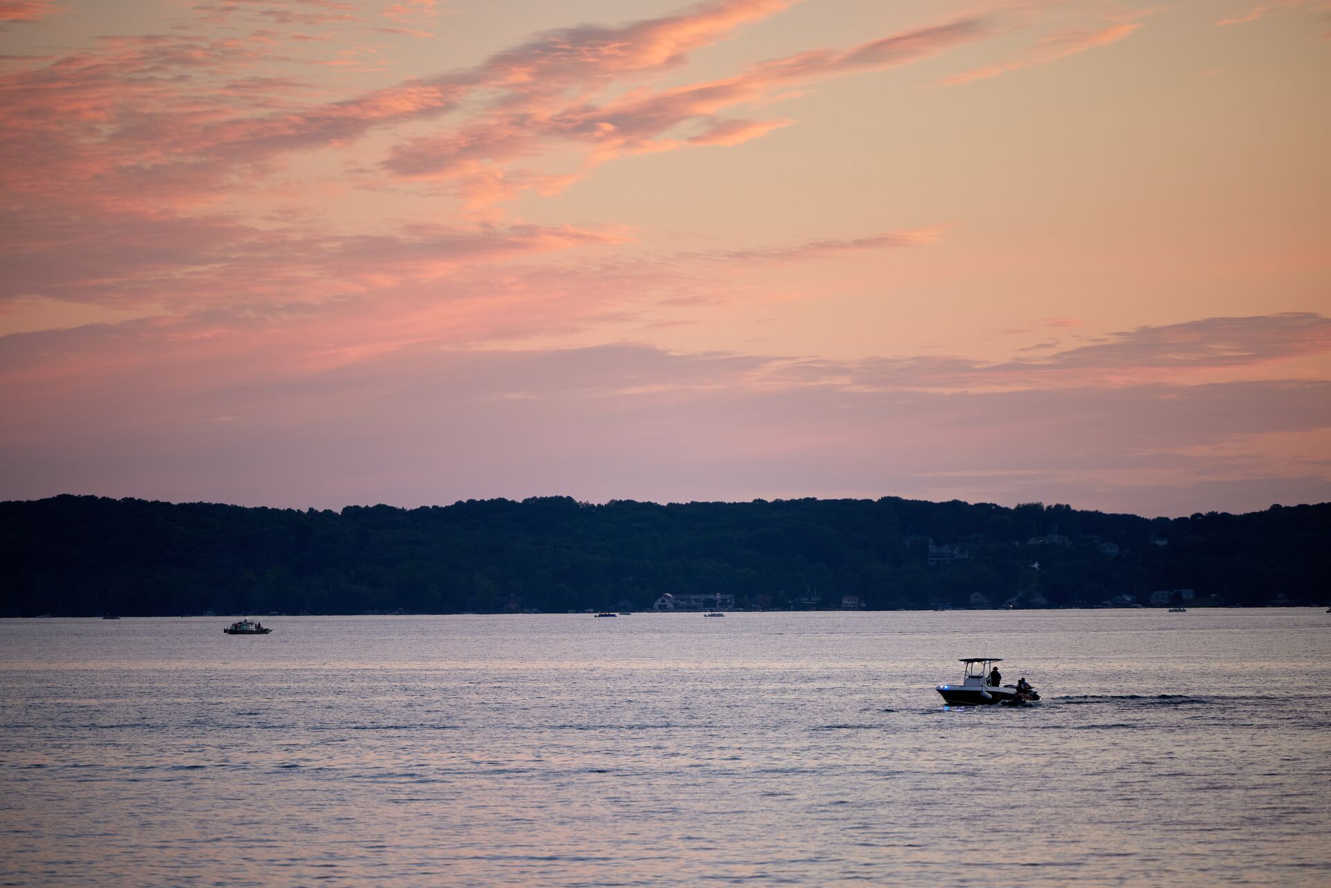Two boats on the water in the distance with dark skies, boating weather warnings concept. 