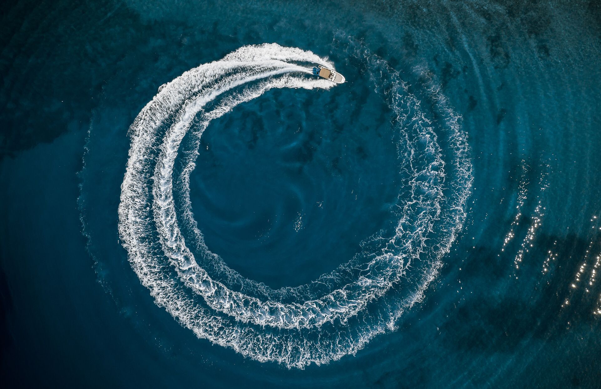 Aerial view of boat driving in circle on water, safe speed rule boating concept. 
