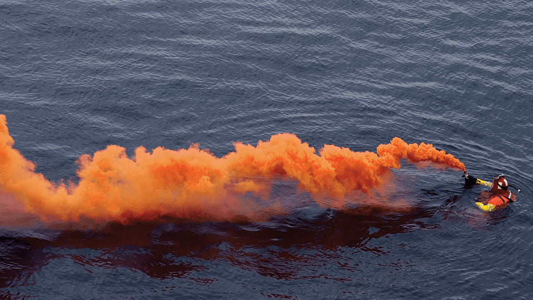 Overhead view of orange flare smoke on the water, understand boat flares concept. 