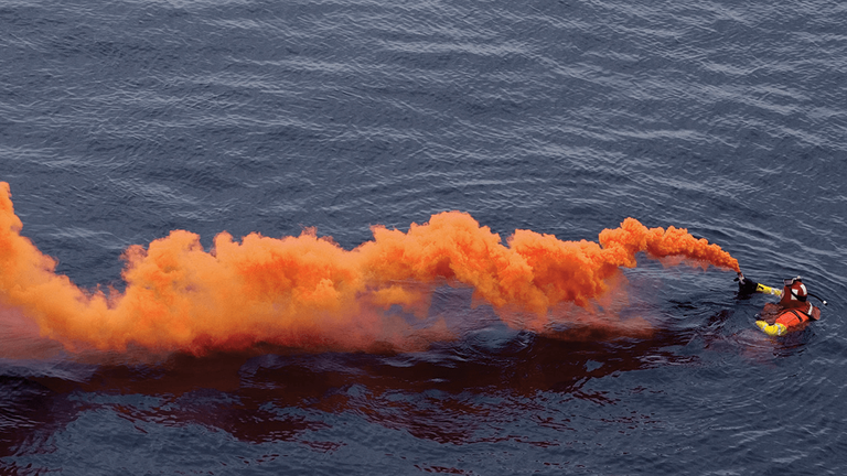 Overhead view of orange flare smoke on the water, understand boat flares concept. 