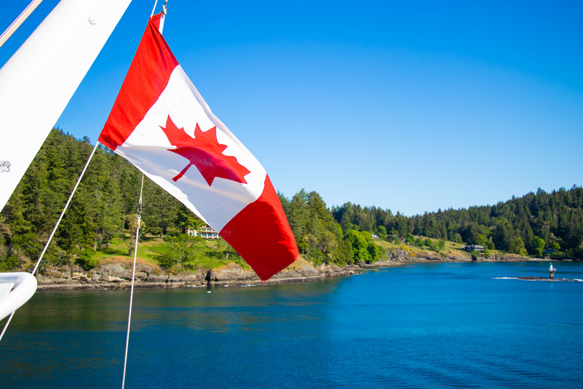 Canadian flag on a boat flies over the water, how much does an Ontario boating license cost concept.
