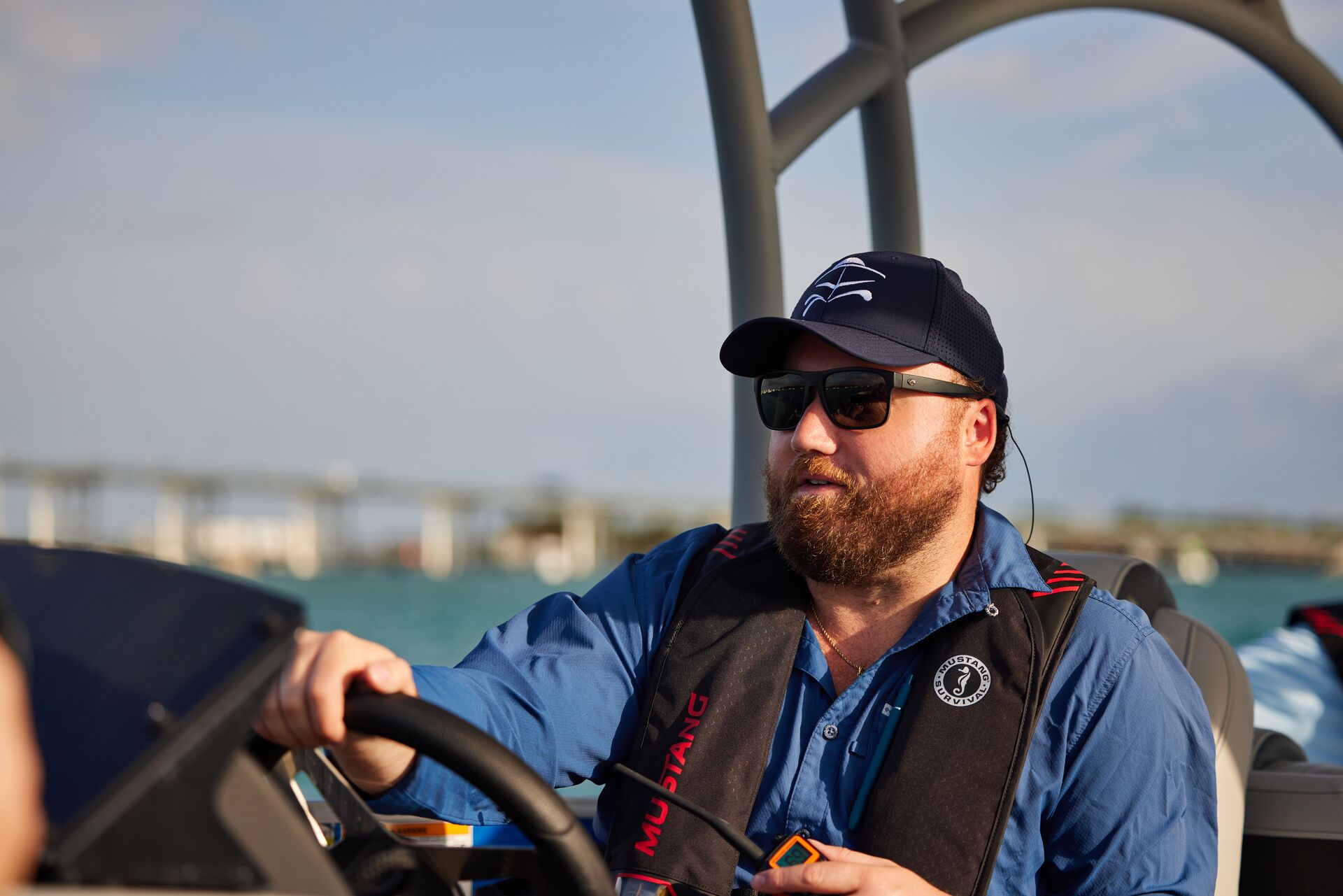 Man in hat and sunglasses drives a boat, take the Alberta boating license test concept.