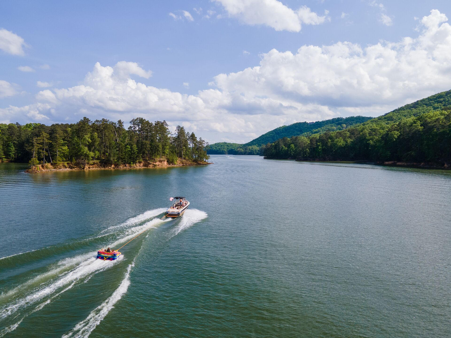 Aerial view of boat pulling tube on lake, how old to get PCOC concept. 