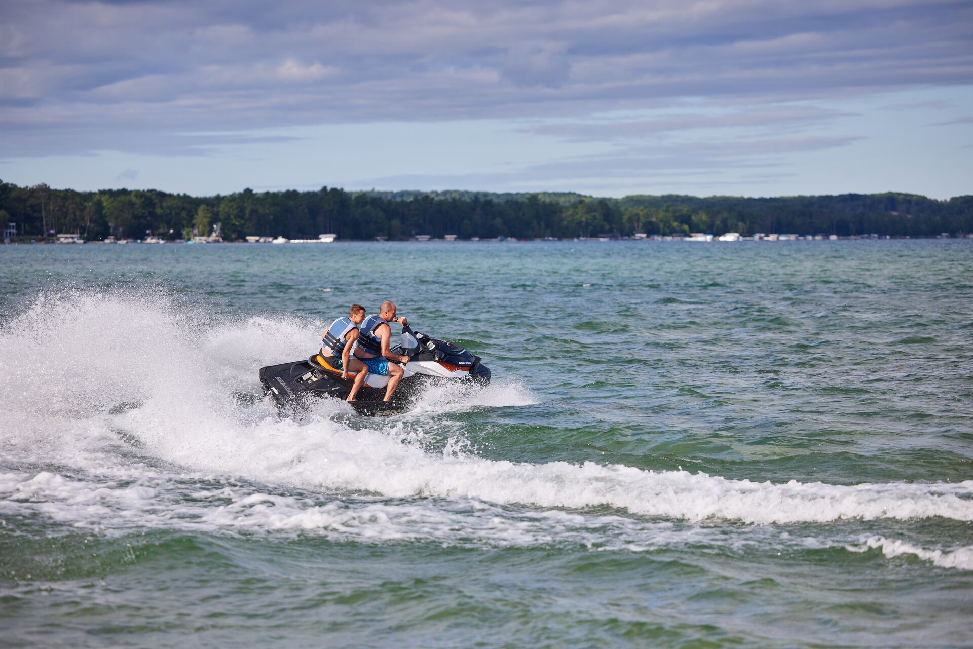 Man and boy make big turn while on jet ski, boating license for jet ski in Ontario concept. 