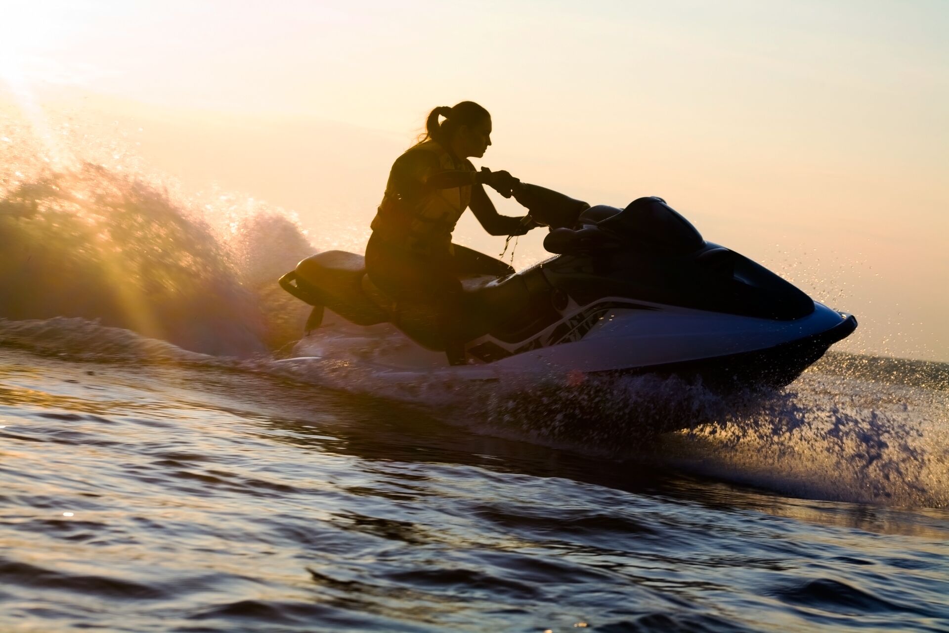 Silhouette of a girl on a jet ski on the water, jet ski license in Manitoba concept.
