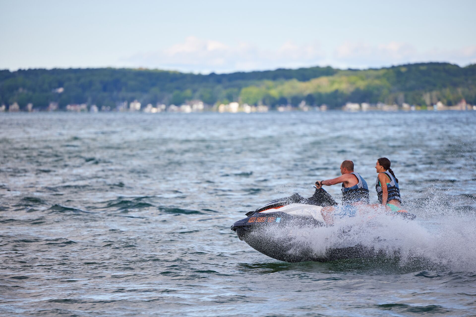 Back view of girl and man on jet ski, boating license for jet ski in New Brunswick concept.