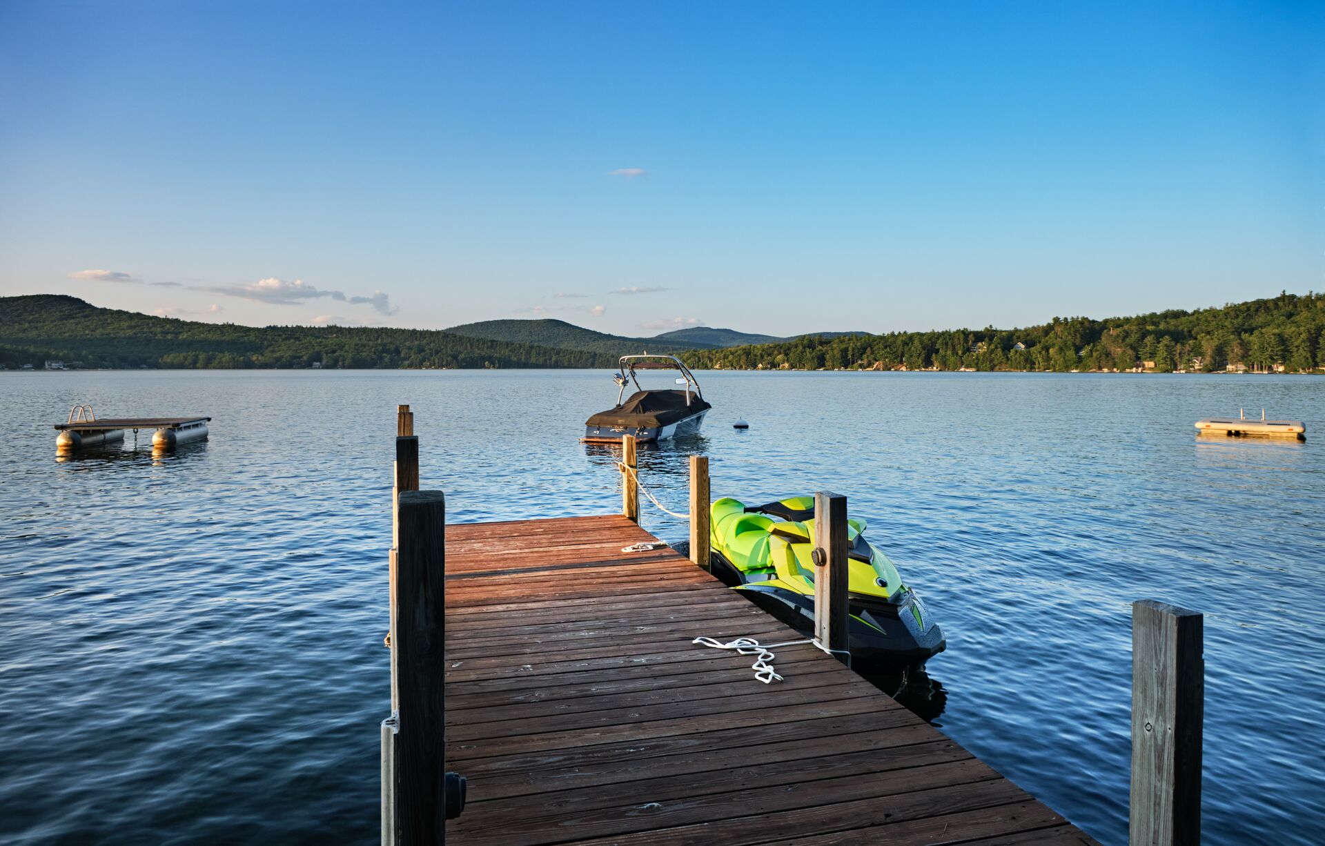 Jet ski at dock with boat in water nearby, jet ski license New Brunswick concept.