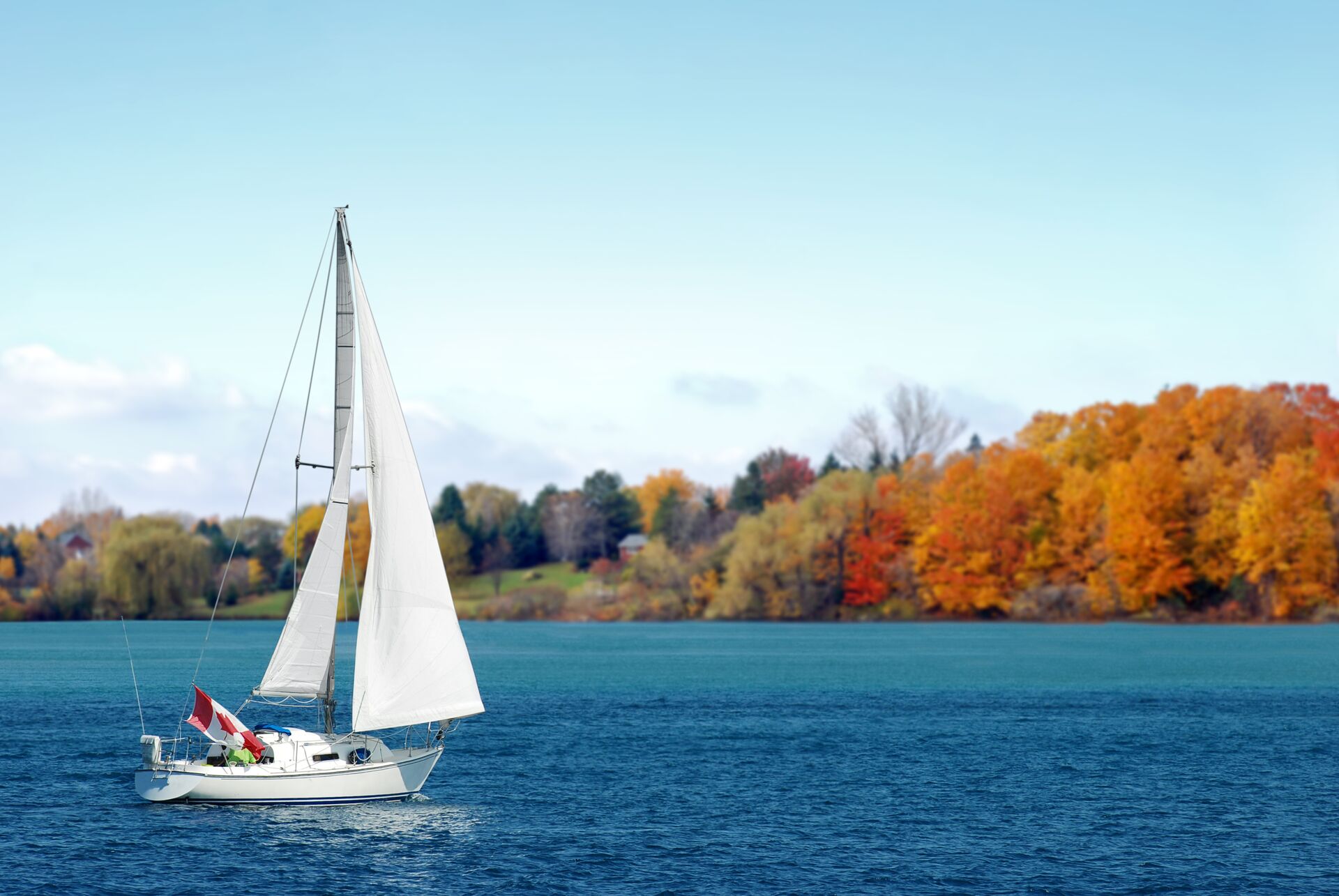 Sailboat on water flying Canadian flag, boat safely in Canada concept.