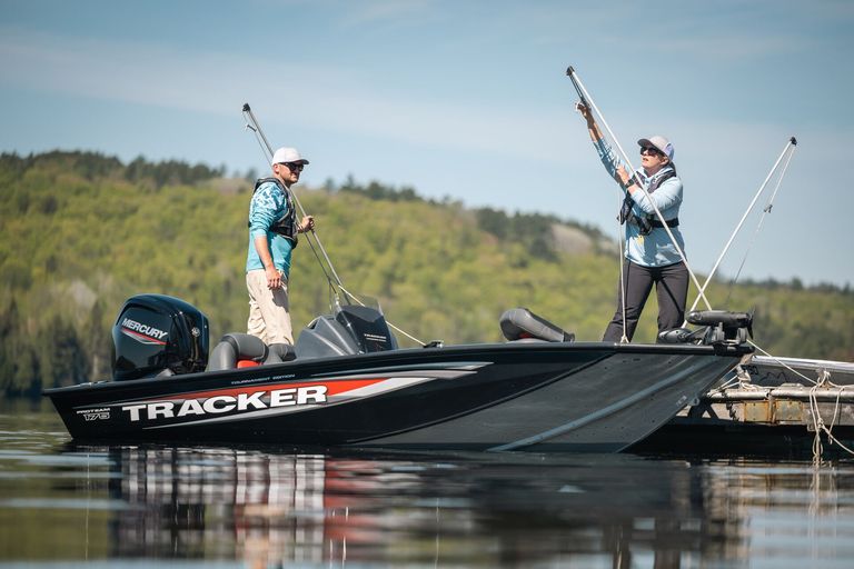 Two people with fishing boat at dock, registering a boat in Canada concept.