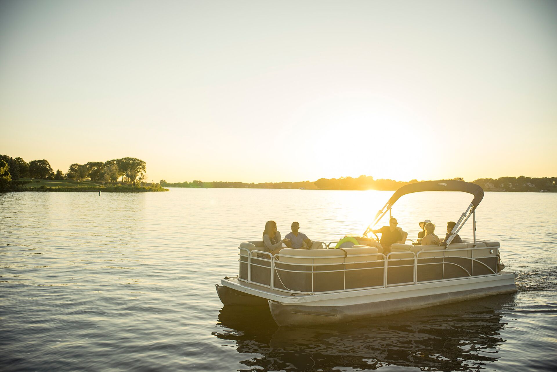 People on pontoon boat on the water, fine for no boating license Canada concept.
