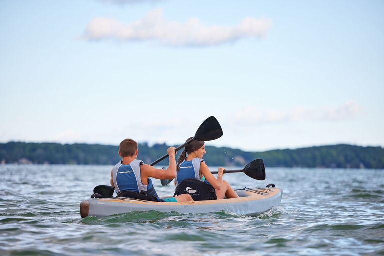 Two kids in lifejackets paddle kayak, do you need a licence for a kayak concept.