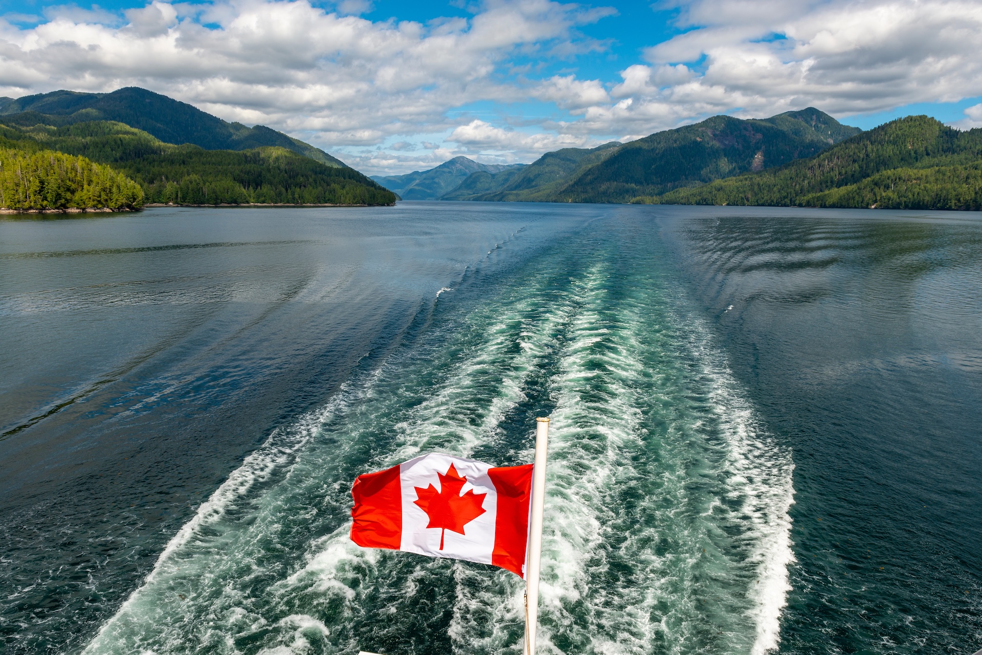 Canada flag flies over the water, PCOC vs Pleasure Craft Licence concept.