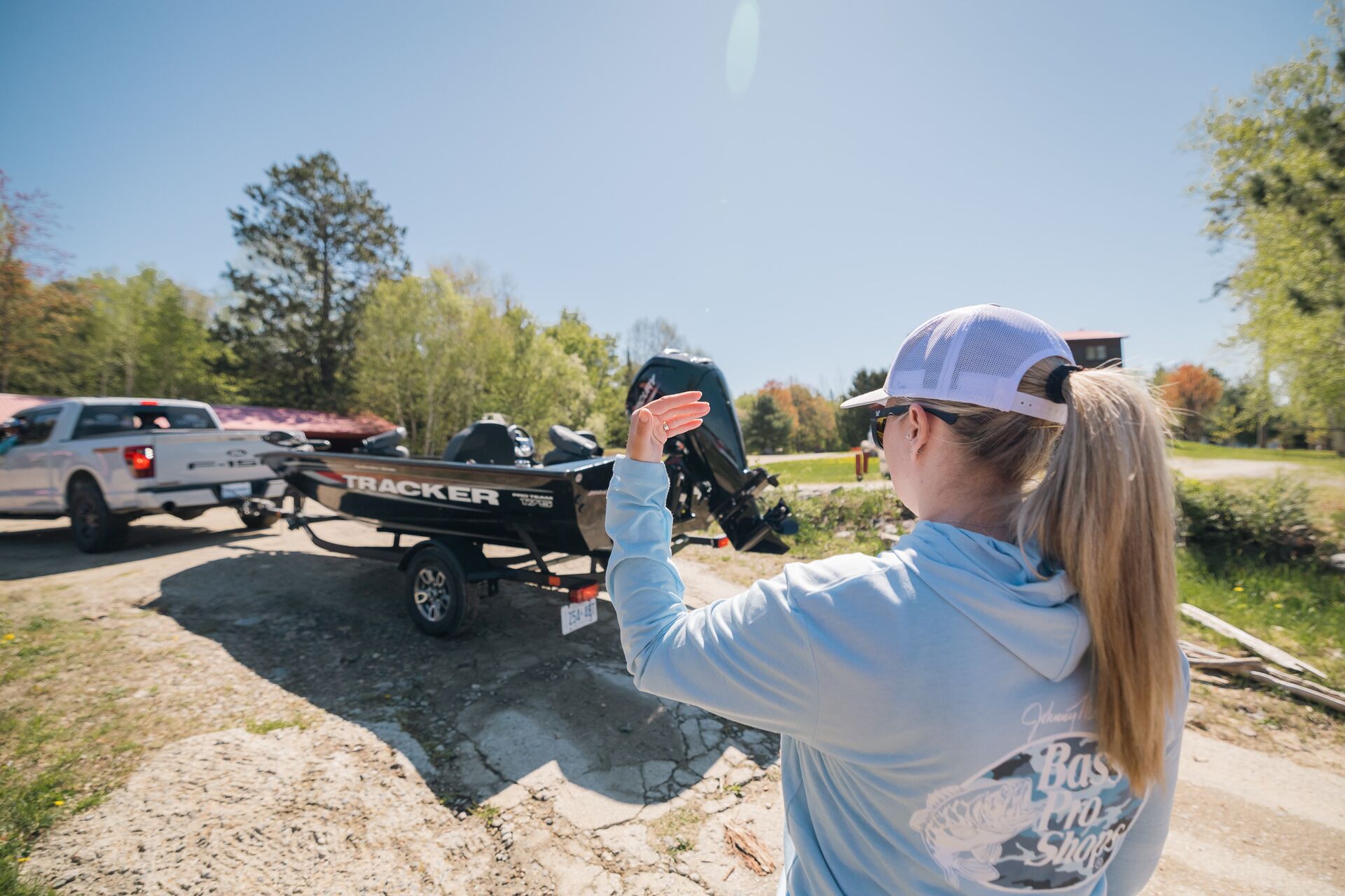Woman directs boat on trailer down ramp, get a Pleasure Craft Operator Card concept.