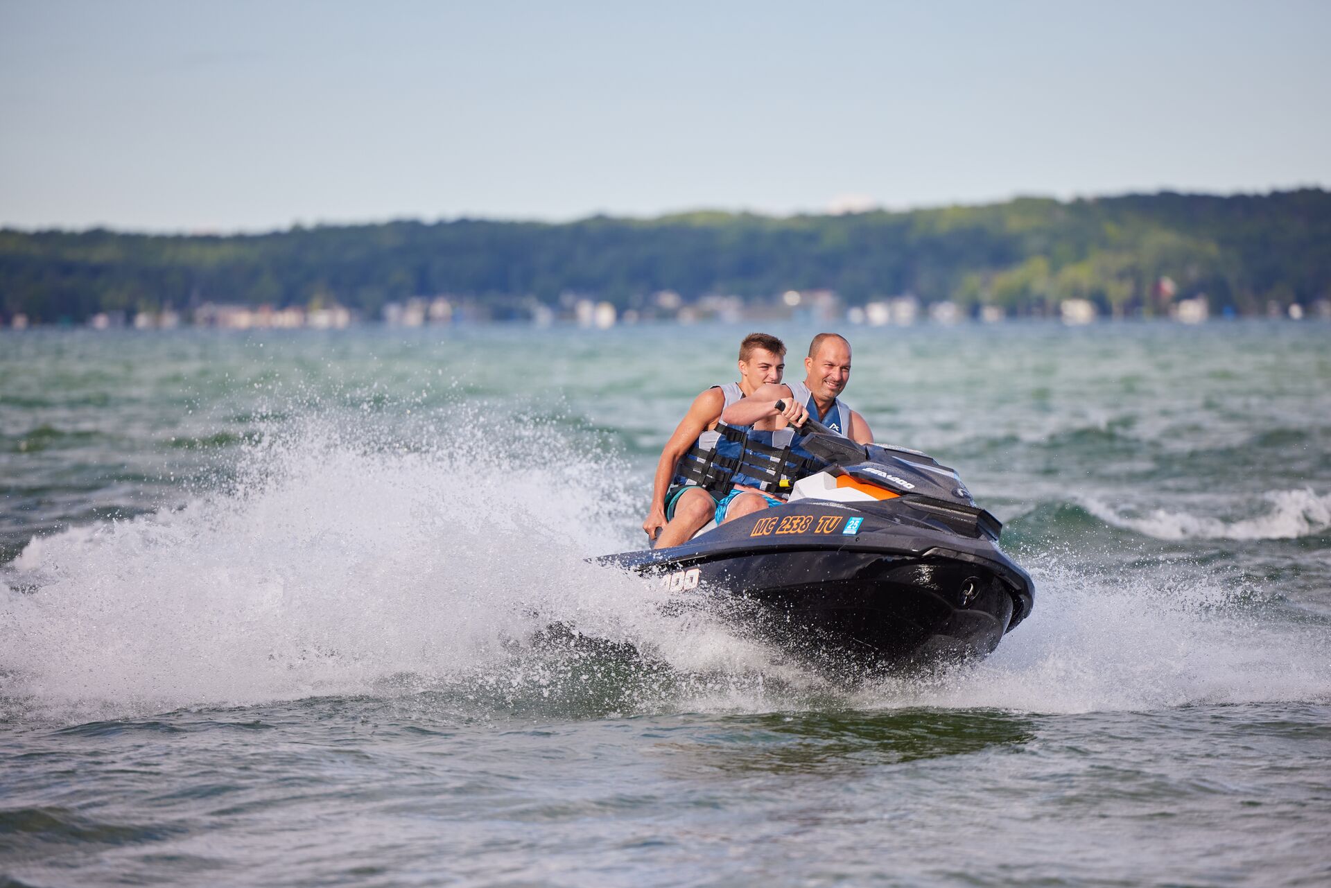 Man and boy smile while riding PWC, how old to operate a PWC Canada concept.