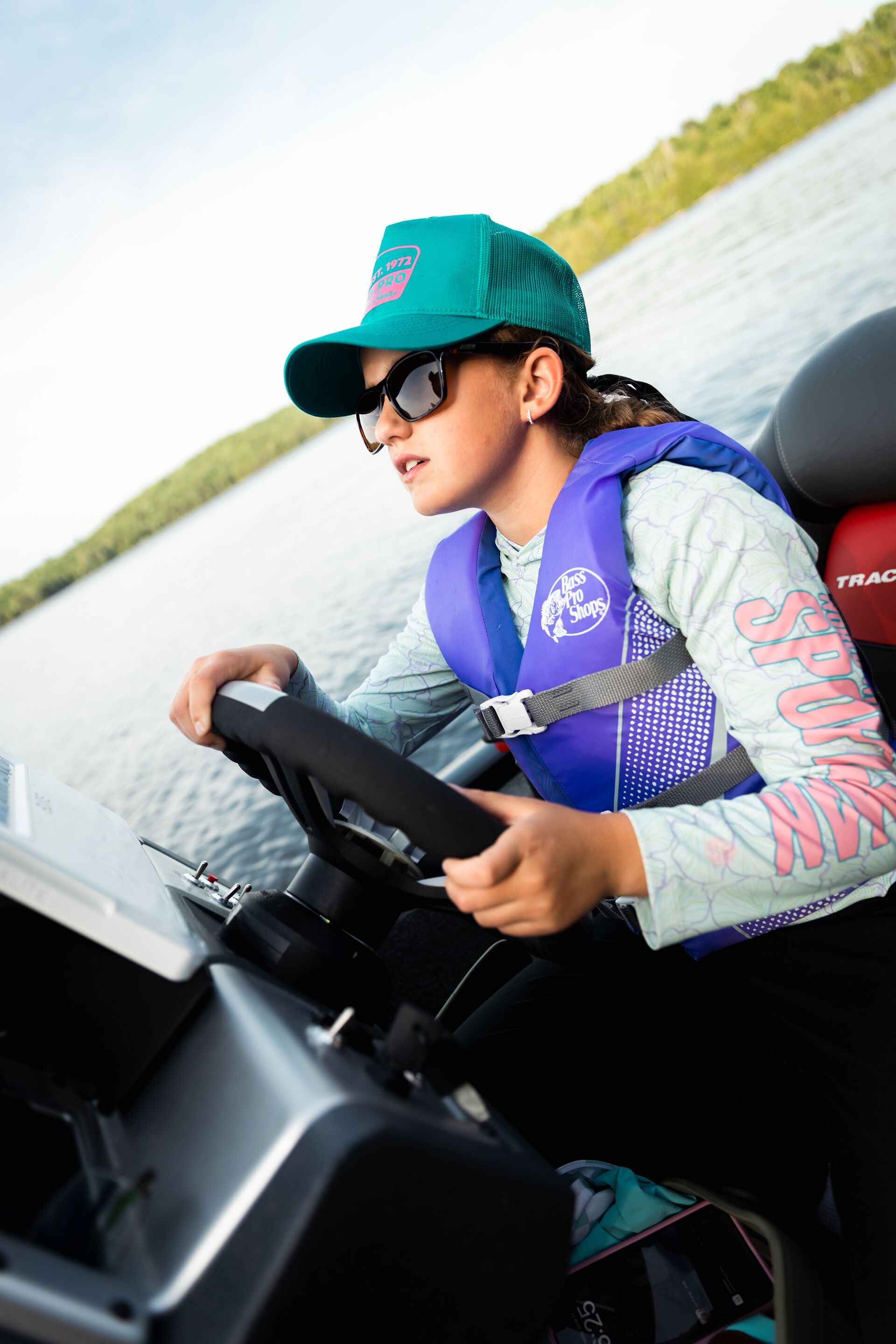 Young girl drives a boat, how old to operate a boat Canada concept.