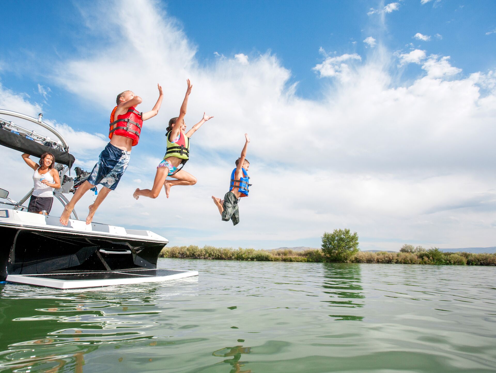 Kids jump from boat into water, boating license to rent a boat concept.