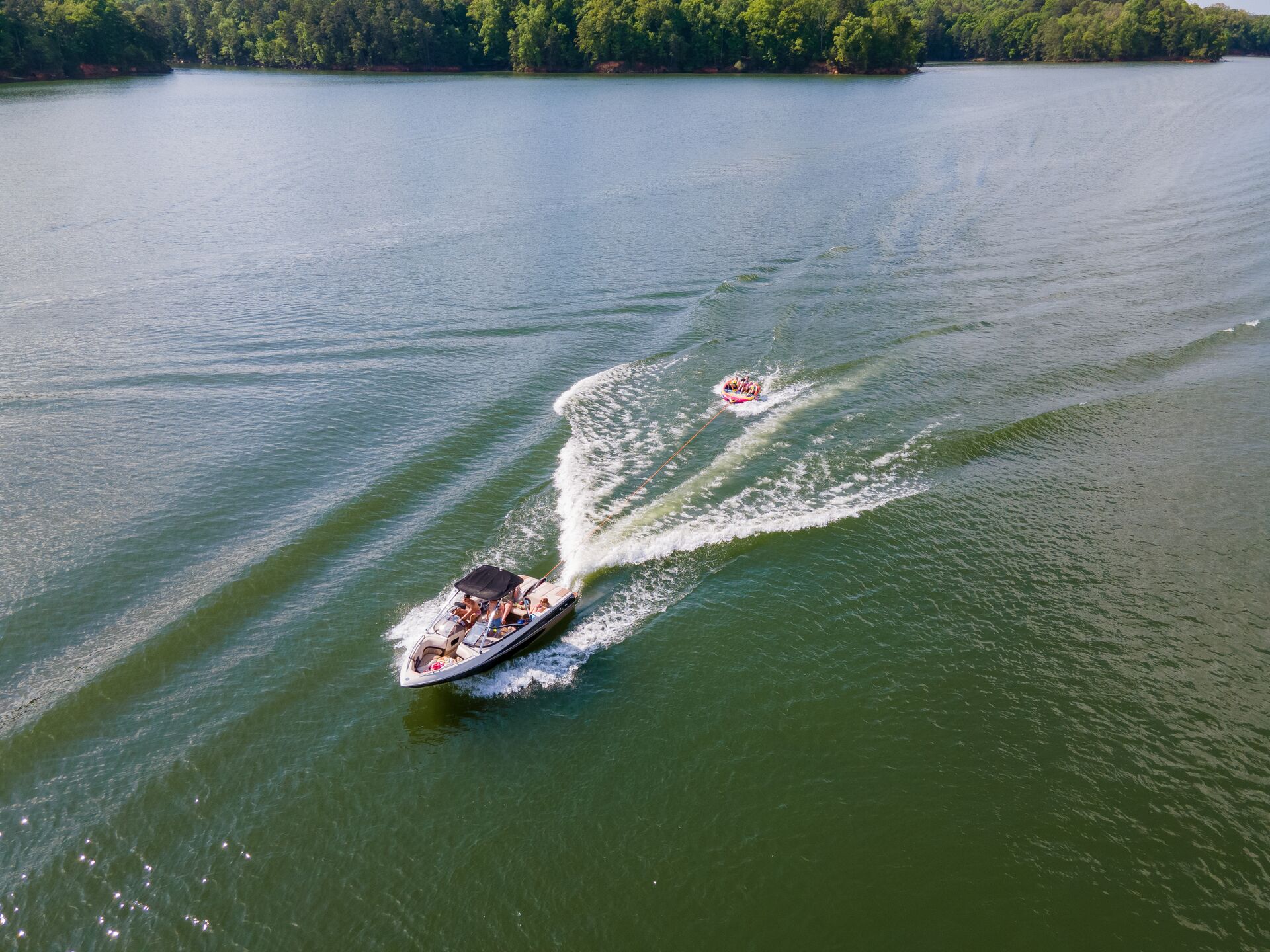 Overhead view boat pulls tube with people, do you need a boating license to rent a boat concept. 