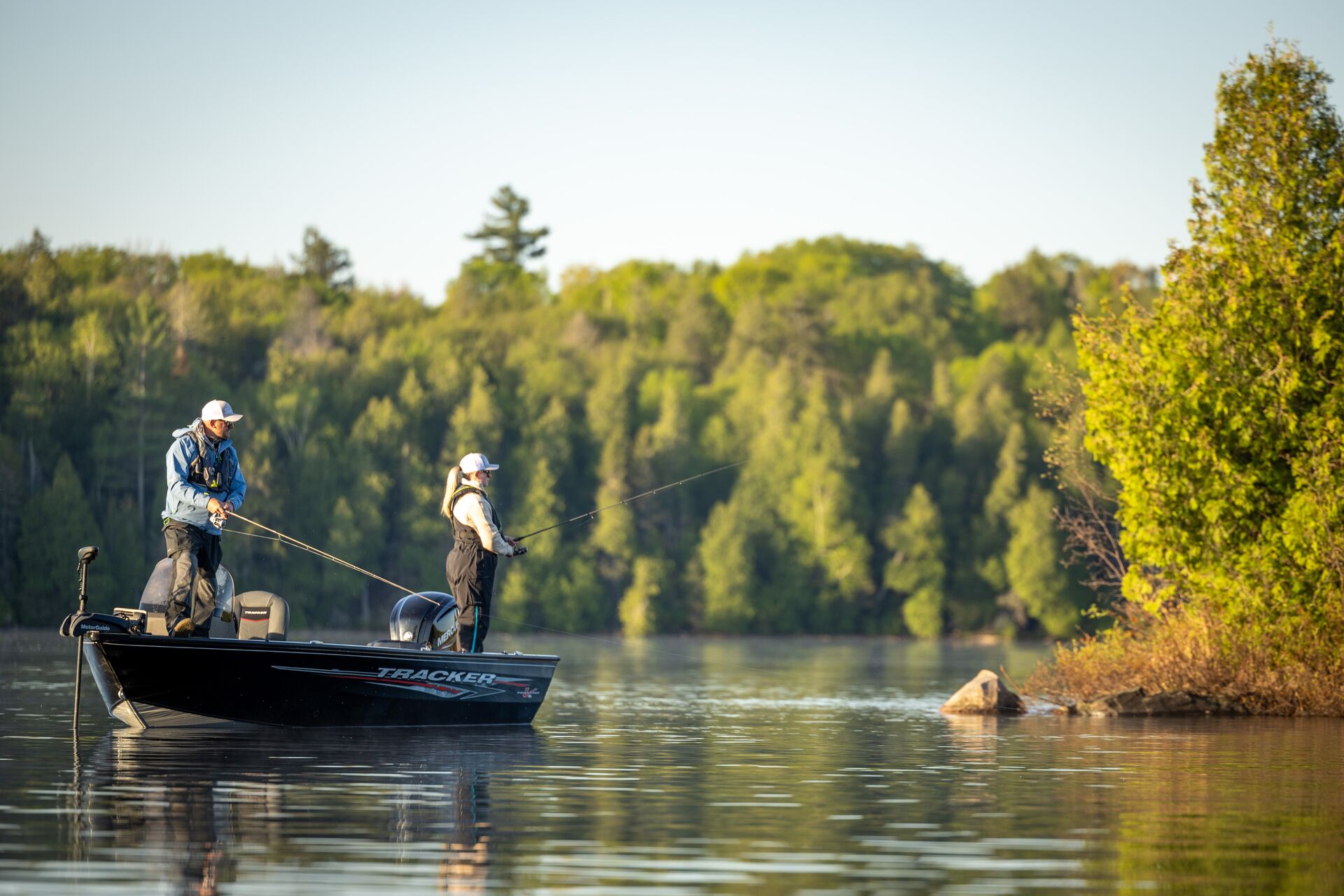 Man and woman fishing from a boat, fishing licence ontario concept.