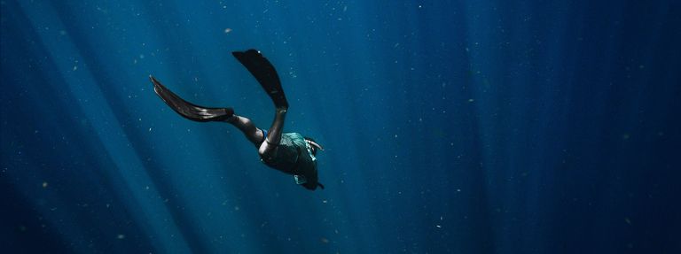 A diver in the water, deep-sea exploration concept. 