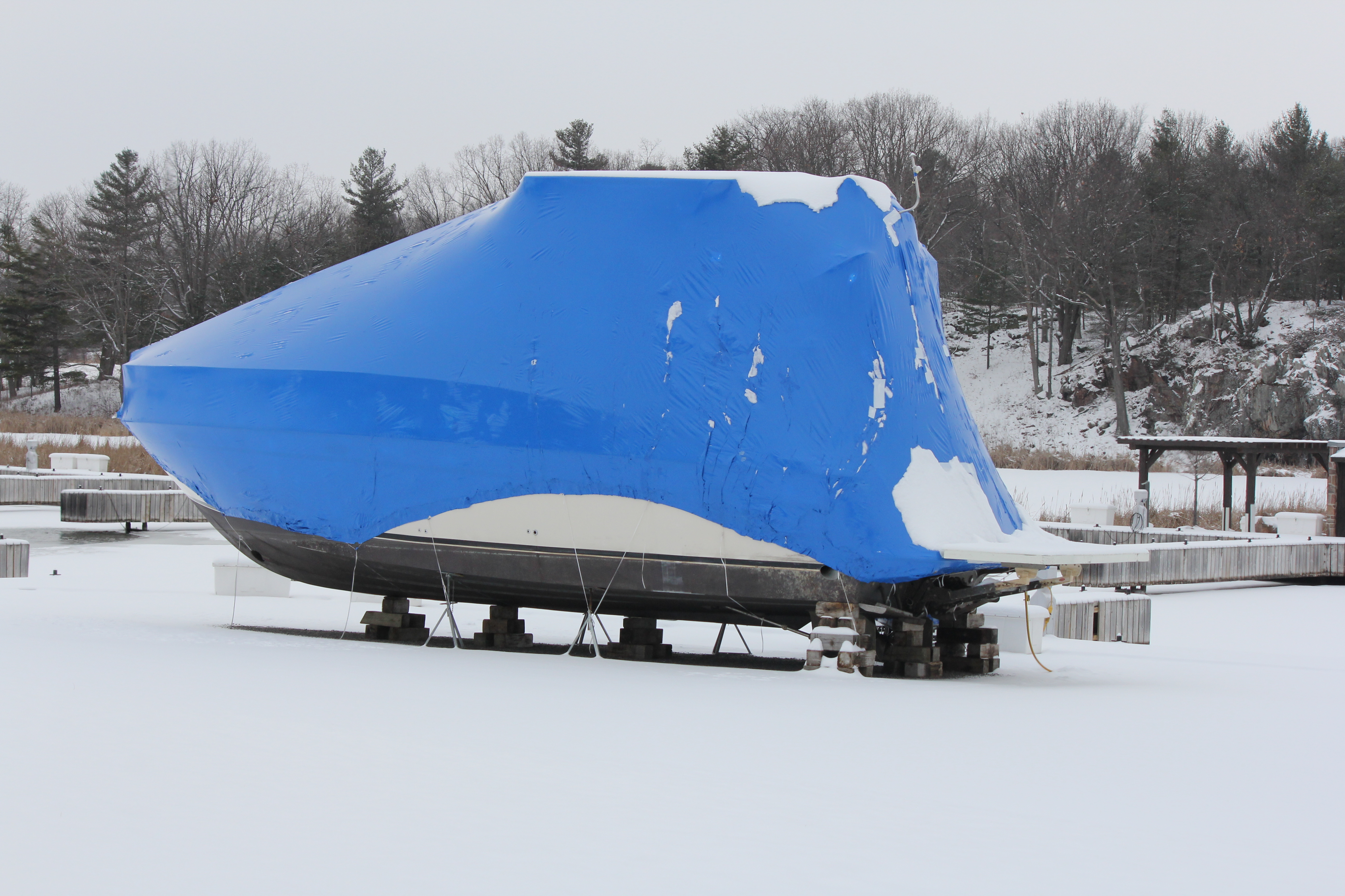 A boat covered and stored, winterizing a boat concept.