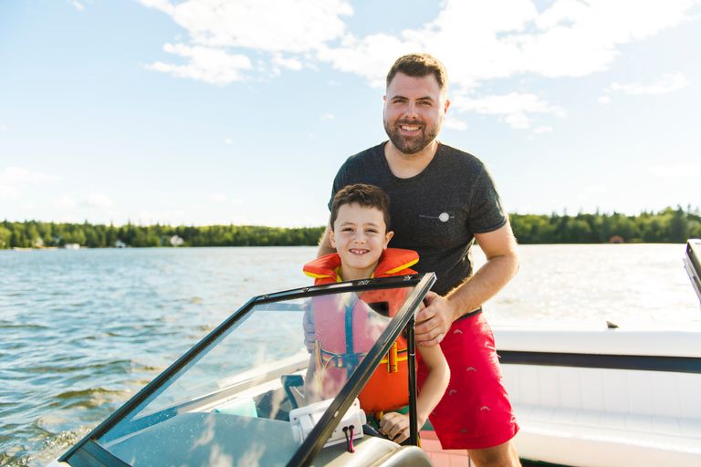 A man and boy smiling on a boat, safe boating concept. 