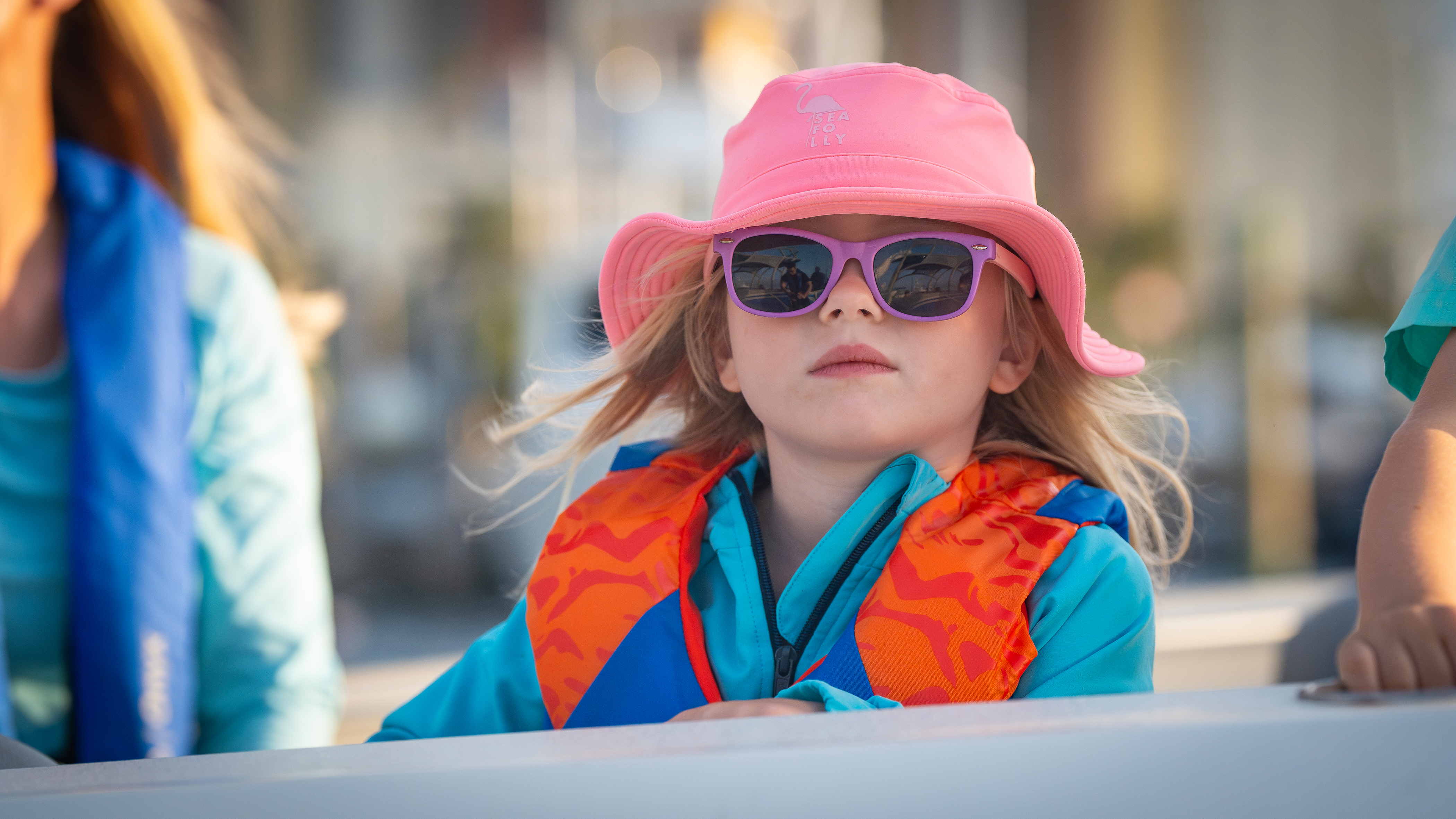 A young girl in sunglasses and a life jacket on a boat, Ontario boating regulations concept. 