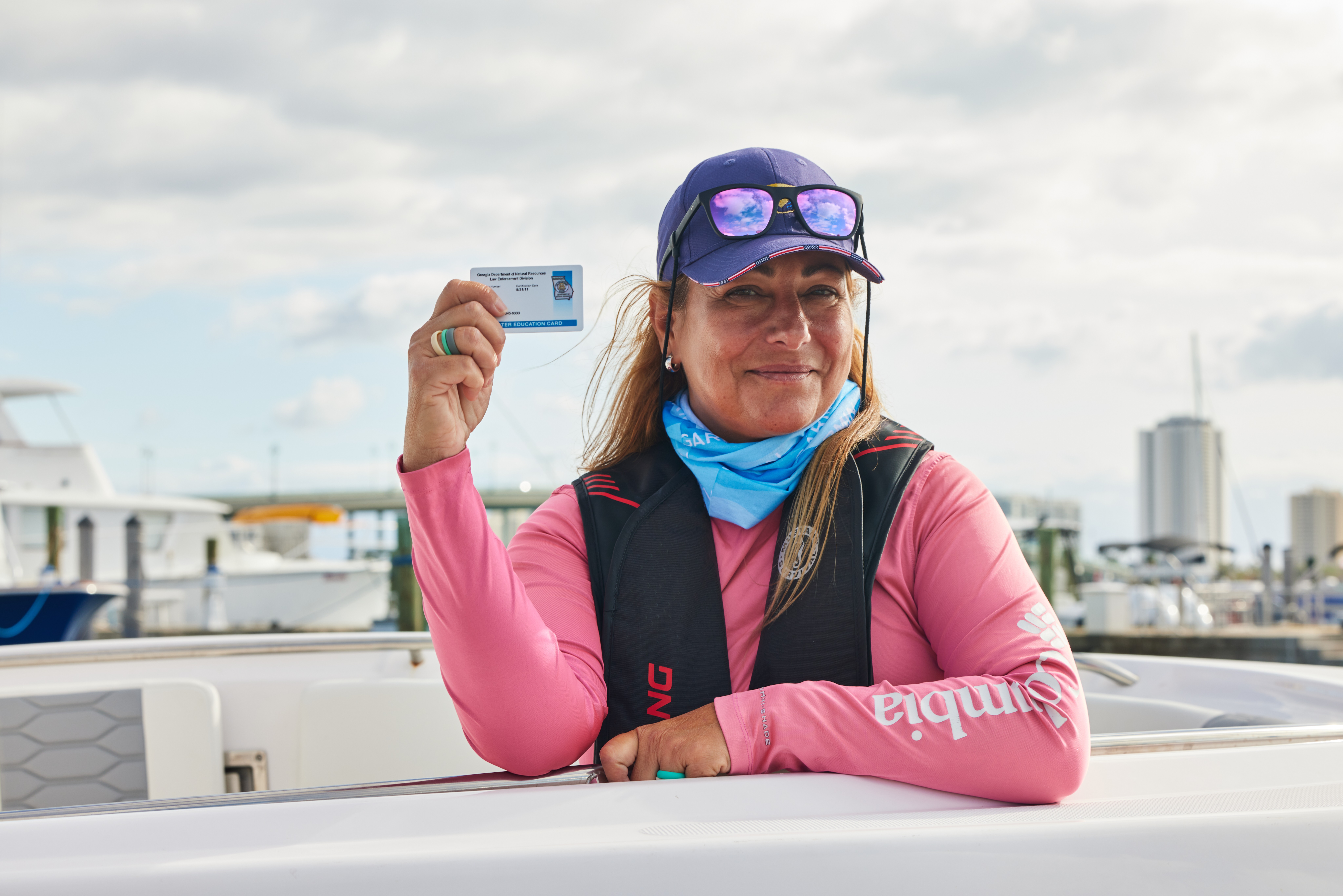 A woman holding a boater card, boat license in Quebec concept. 