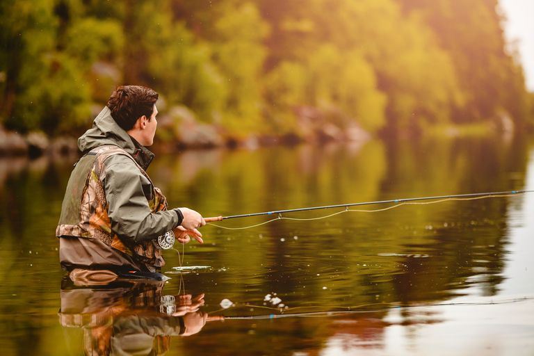  A man fishing in the water, using a fish finder concept. 