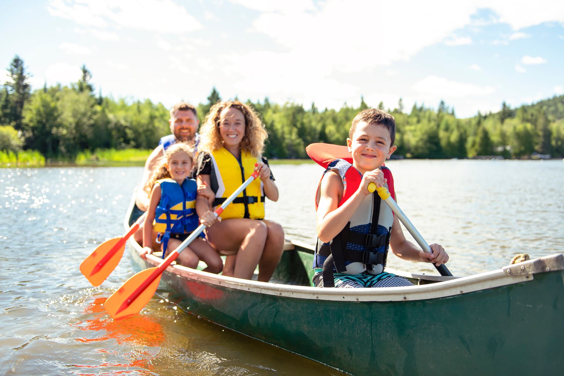 Adults and kids in a canoe while wearing lifejackets, canoe lifejacket concept. 