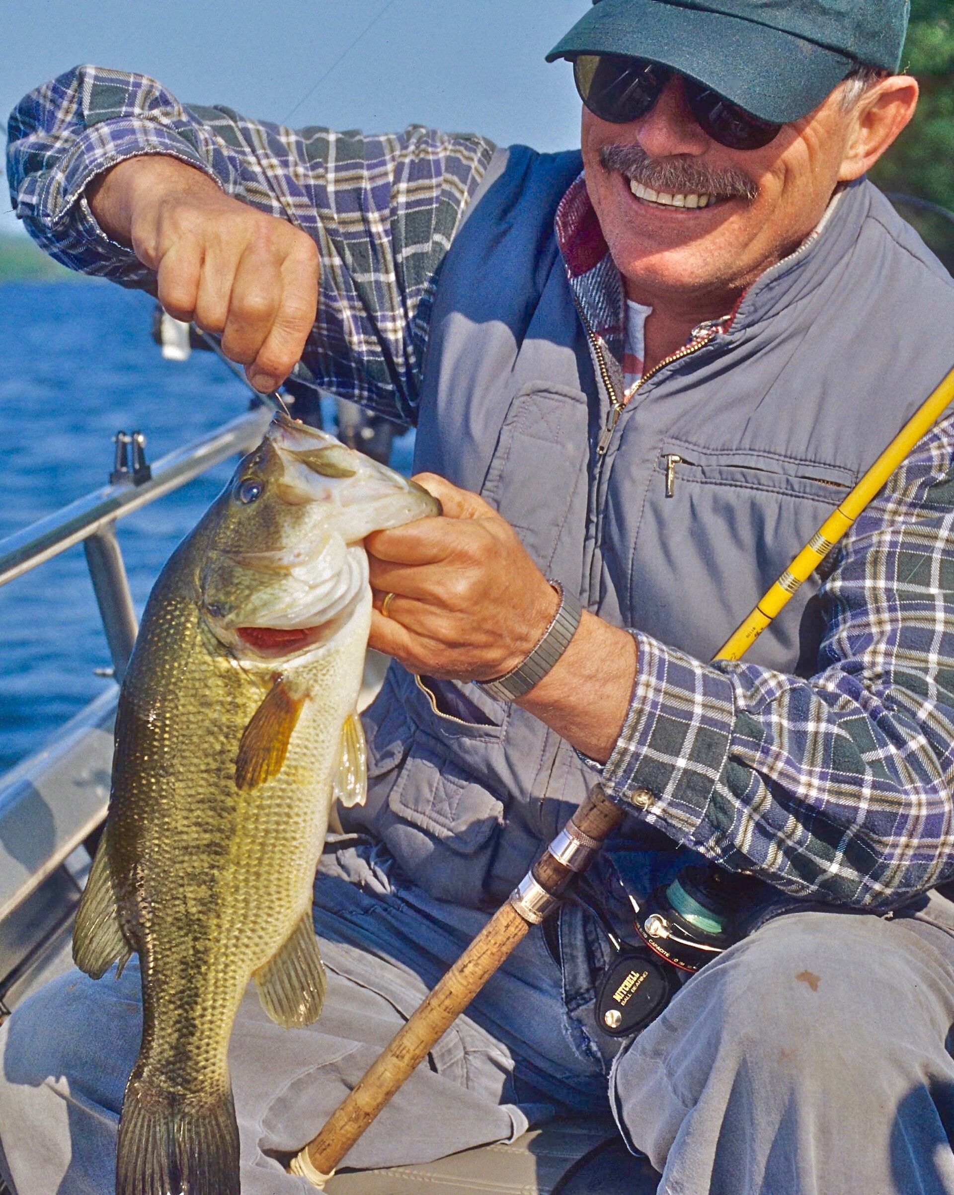 A man holds a fish and removed the hook, using a palomar knot for fishing concept.