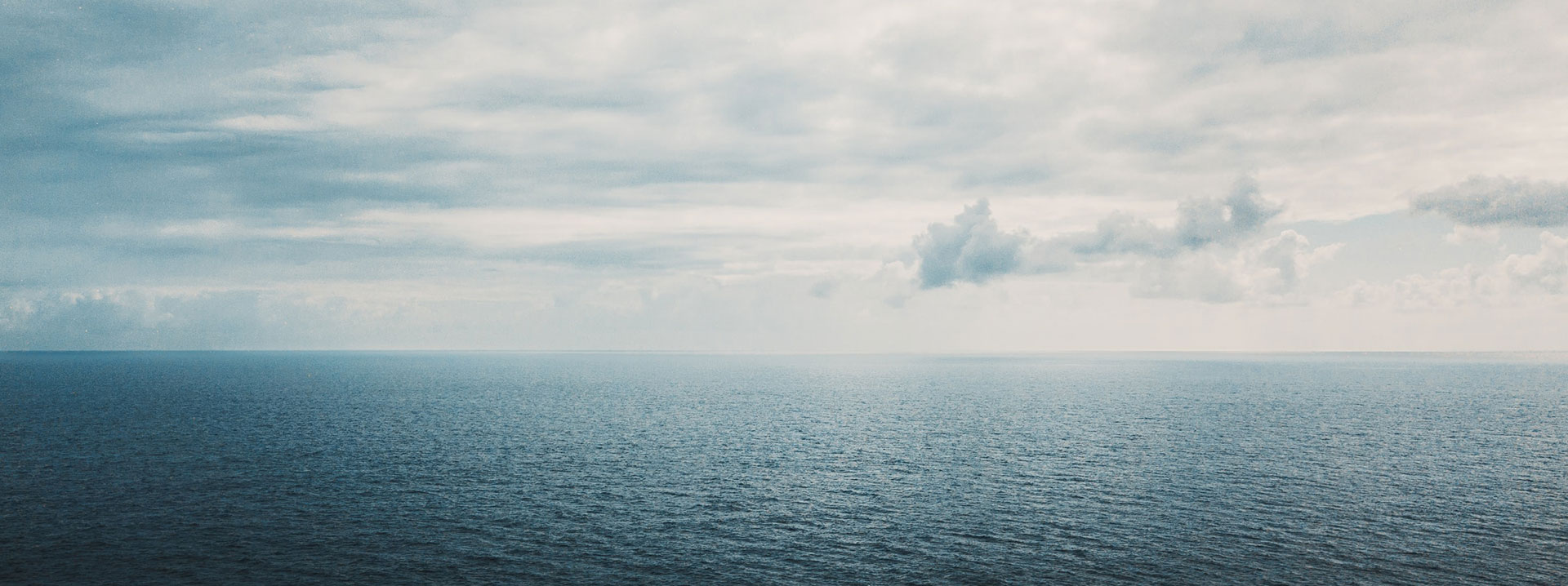 A wide view of the water and sky, boats lost at sea concept. 