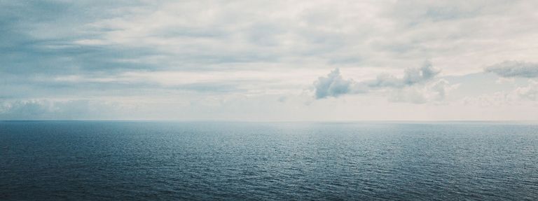 A wide view of the water and sky, boats lost at sea concept. 