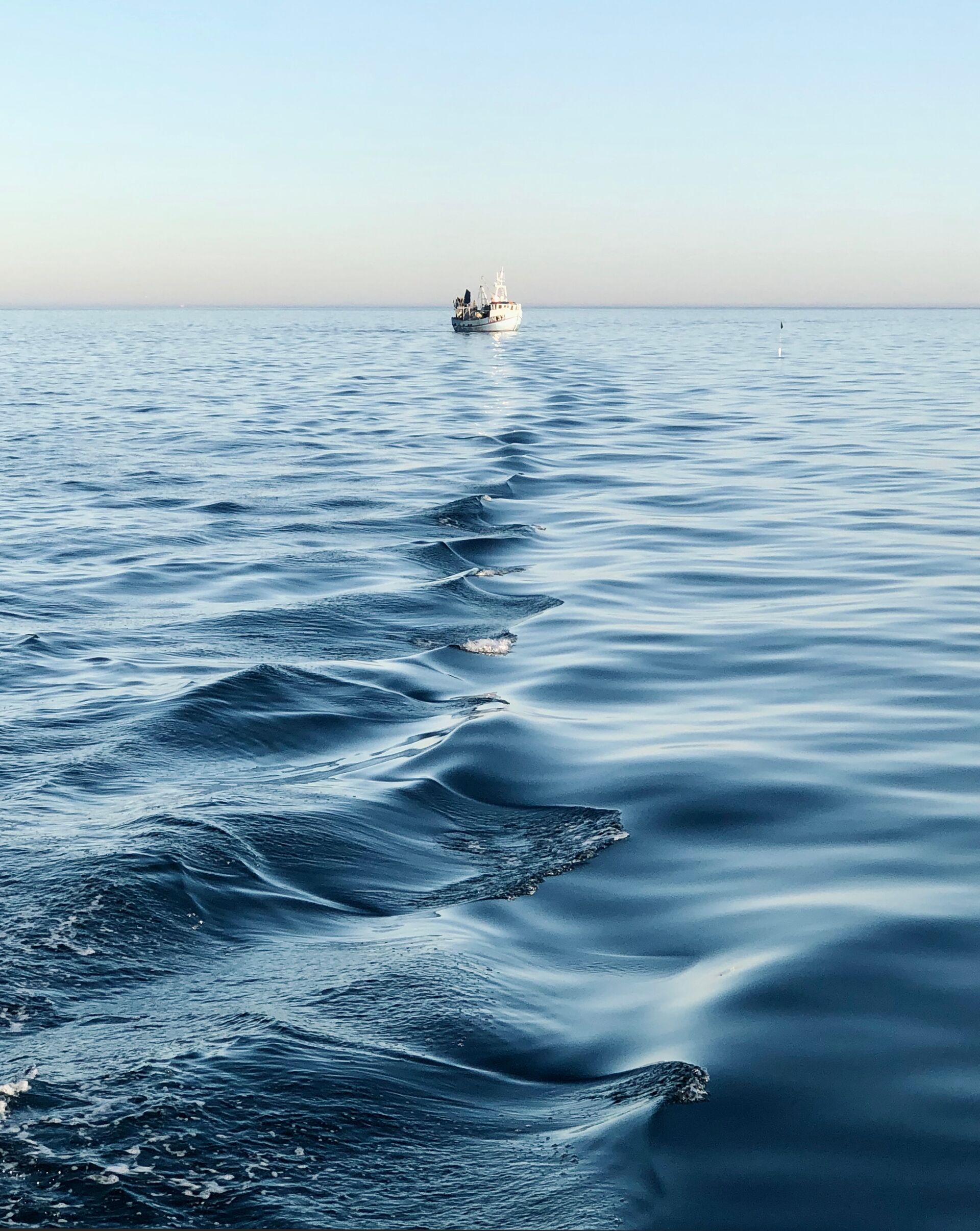 A boat in the distance on the ocean, boating on the ocean concept.