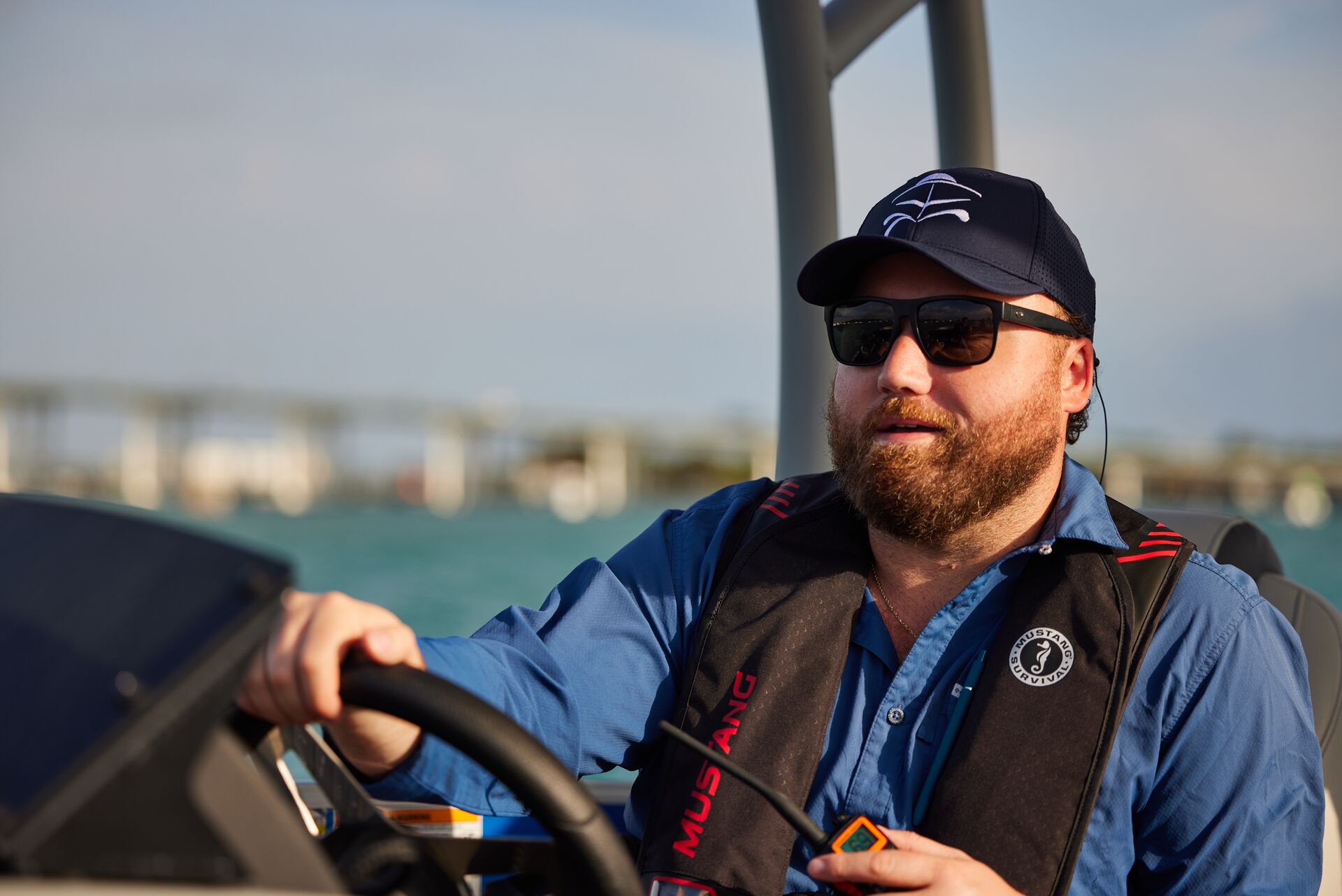 A man smiles and swears a life jacket while holding a radio, safety when boating concept.