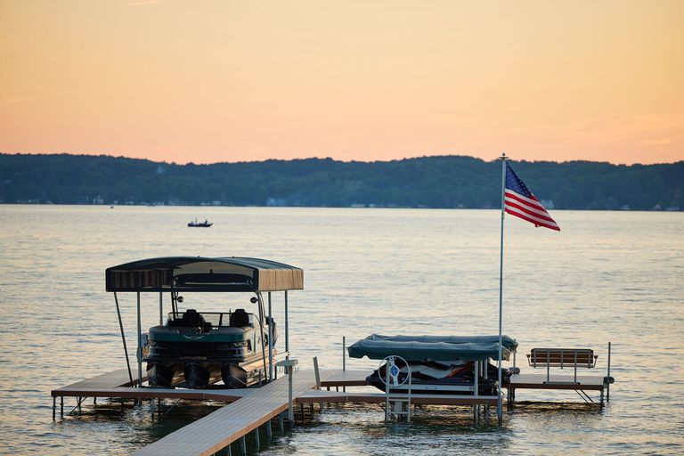 A boat docked out of the water near an American flag.