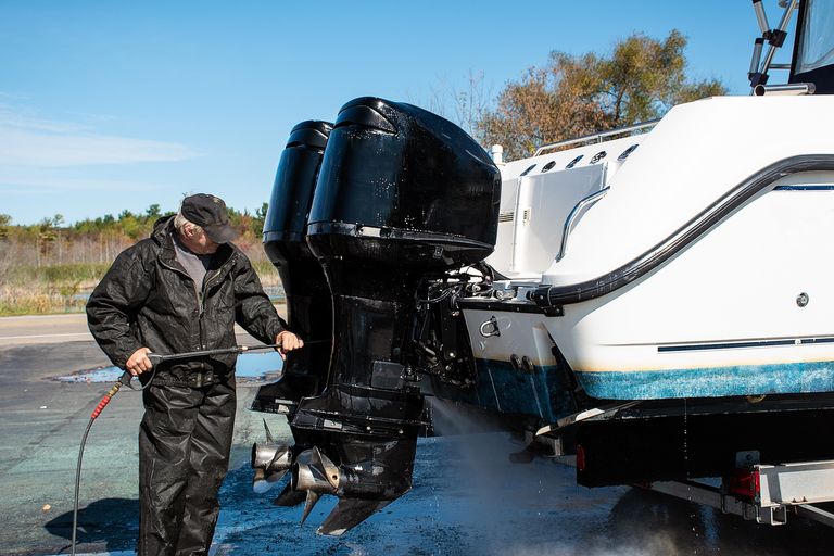 A man cleans boat engines, annual boat maintenance checklist concept. 
